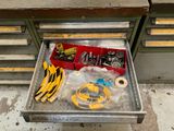 un tiroir rempli d'outils posé par terre dans le garage