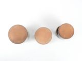 three wooden knobs on a white surface with a white background