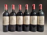six bouteilles de vin sont alignées sur une table