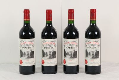 trois bouteilles de vin rouge sont alignées sur une surface blanche