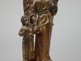 an antique bronze figurine of an angel holding a child