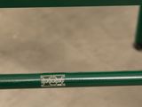 a close up of a green bench with a sticker on it
