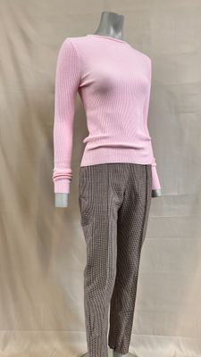 une photo d'un mannequin portant un pull rose et un pantalon marron