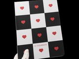 someone is holding up a book with hearts on it