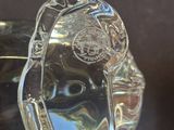 a clear glass object on a table with a black background