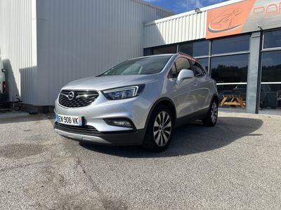 un SUV Buick argenté garé devant un immeuble