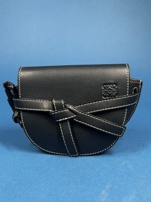 the small black leather purse is on a blue surface