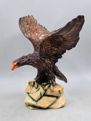 une image représentant une statue d'aigle au sommet d'un rocher