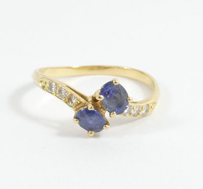 a yellow gold ring with two blue sapphires and diamonds