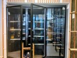une porte vitrée qui donne sur une pièce remplie d'étagères, les unes après les autres