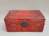 une petite boîte rouge ornée de motifs dorés