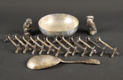 de nombreuses cuillères en argent et un bol posés sur une table