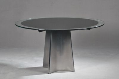 une table en verre avec un piètement en métal posée sur un sol blanc