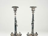 pair of silver candlesticks with figures on the sides