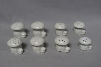 a lot of small white ceramic mushrooms on the table
