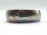 a close up of a metal bracelet with a design on it