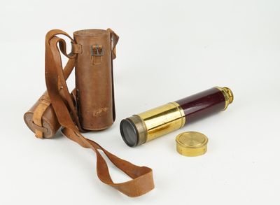 an old telescope with a leather case next to it