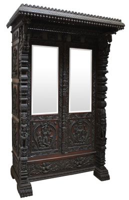 armoire en bois sculpté surmontée de deux miroirs