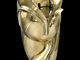 une sculpture en or représentant le visage d'une femme sur fond noir