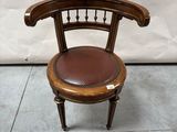 a wooden chair with a leather seat on a tile floor
