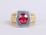 a picture of a ring with a red stone in it