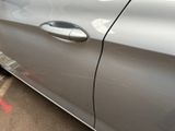 a silver car parked in a parking lot next to a parking meter