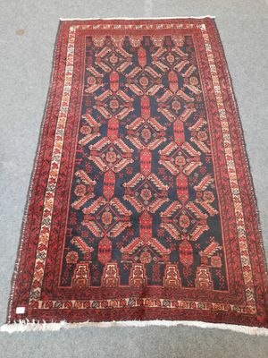 un vieux tapis persan aux motifs rouges et bleus