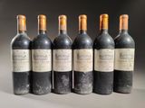 six bottles of wine are lined up in a row on a table