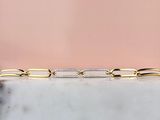 un gros plan d'un bracelet en or et diamants posé sur une surface en marbre