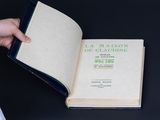 someone is holding a book open on a table with a black background