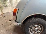 a small blue car parked on the side of the road