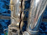silver plated alto saxophone sitting on a blue velvet surface