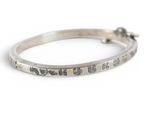 an image of a close up of a silver bracelet with words on it