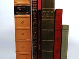 plusieurs vieux livres sont empilés sur une surface blanche