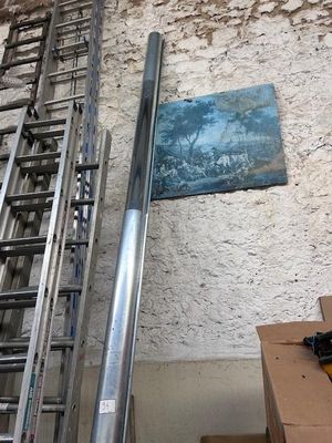 a metal ladder leaning against a wall next to a box of boxes