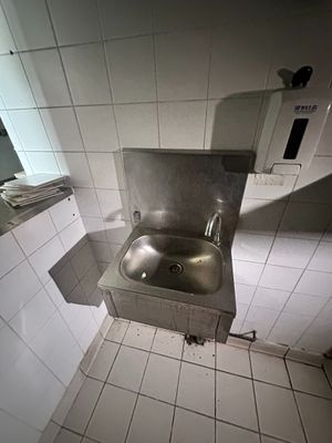 un lavabo dans un coin de toilettes publiques
