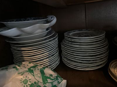 beaucoup d'assiettes empilées sur une étagère dans la cuisine