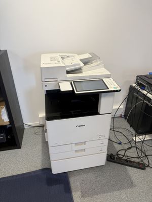 une imprimante posée par terre à côté d'un clavier