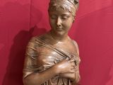 a statue of a woman sitting on top of a wooden table