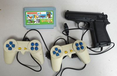 deux manettes de jeu vidéo et un pistolet posés sur une table