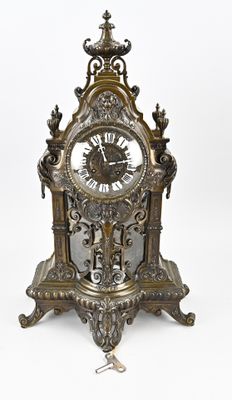 a clock that is sitting on a stand on a white surface