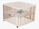 a small wooden crib with a mattress in it