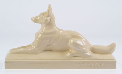 statue d'un chien couché sur un socle, sur fond blanc
