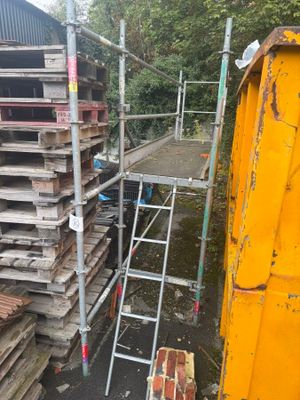 une échelle posée à côté d'une pile de palettes