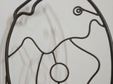 metal sculpture of a fish on a stand on a white surface