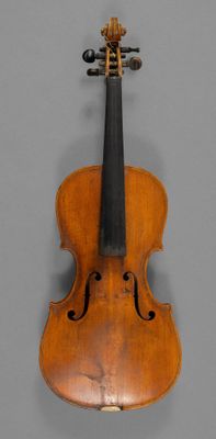 an old violin sitting on top of a table next to a gray wall
