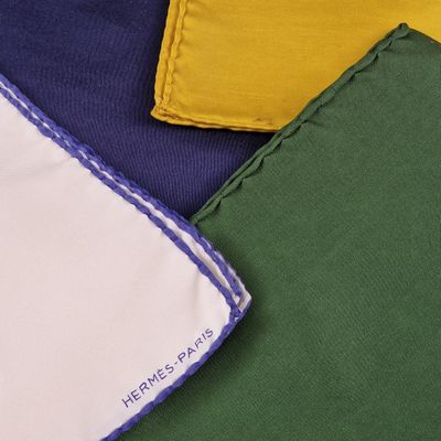 trois serviettes de table de couleurs différentes, ornées d'un logo