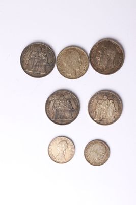 several different coins are arranged in a row on a white surface