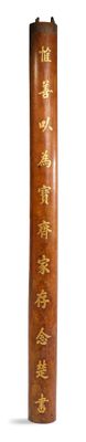 a tall wooden vase with gold writing on it