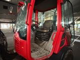 a red tractor that is parked inside of a building